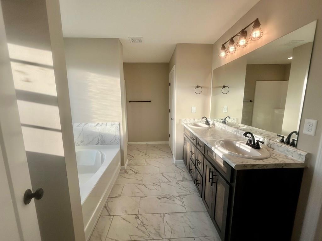 4603 Brees Way Valdosta, GA 31601 - Photo 16 of 31 a bathroom with a double vanity sink a large mirror and a shower