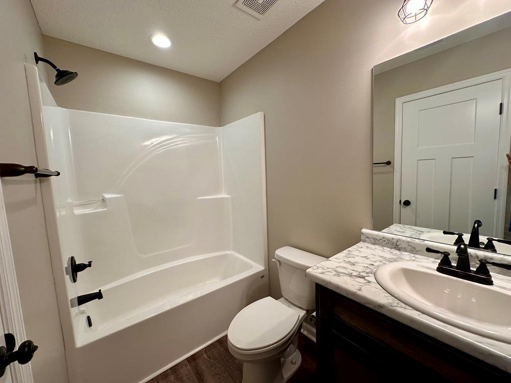4603 Brees Way Valdosta, GA 31601 - Photo 24 of 31 a bathroom with a sink a toilet and a large mirror