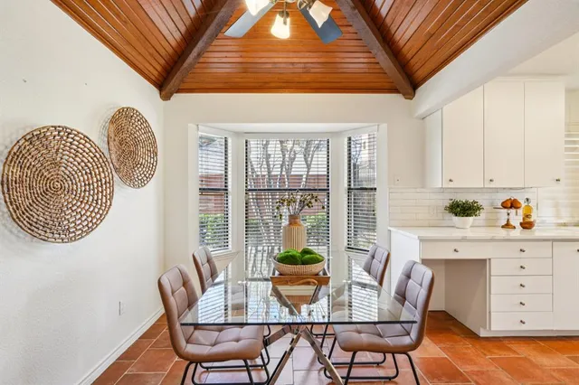 a dining room with furniture a potted plant and a chandelier