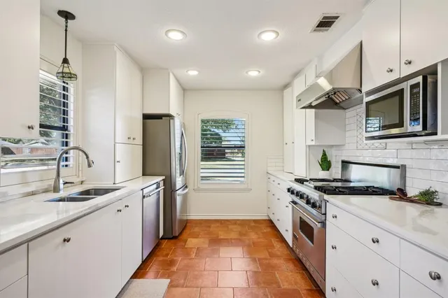 a kitchen with stainless steel appliances granite countertop a sink and a stove