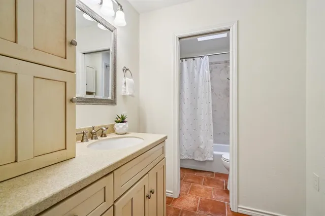 a bathroom with a sink a toilet and a mirror