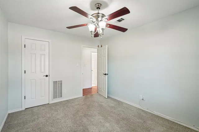 an empty room with fan and windows