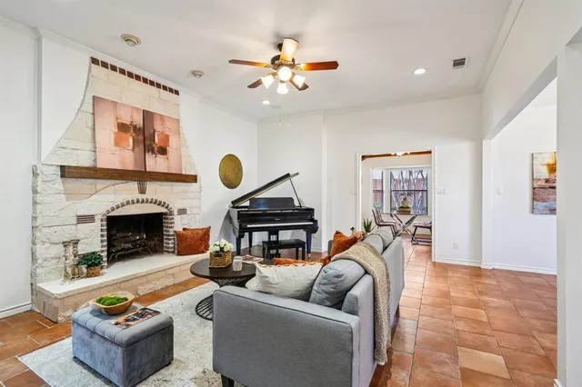 a living room with furniture a fireplace and a large window