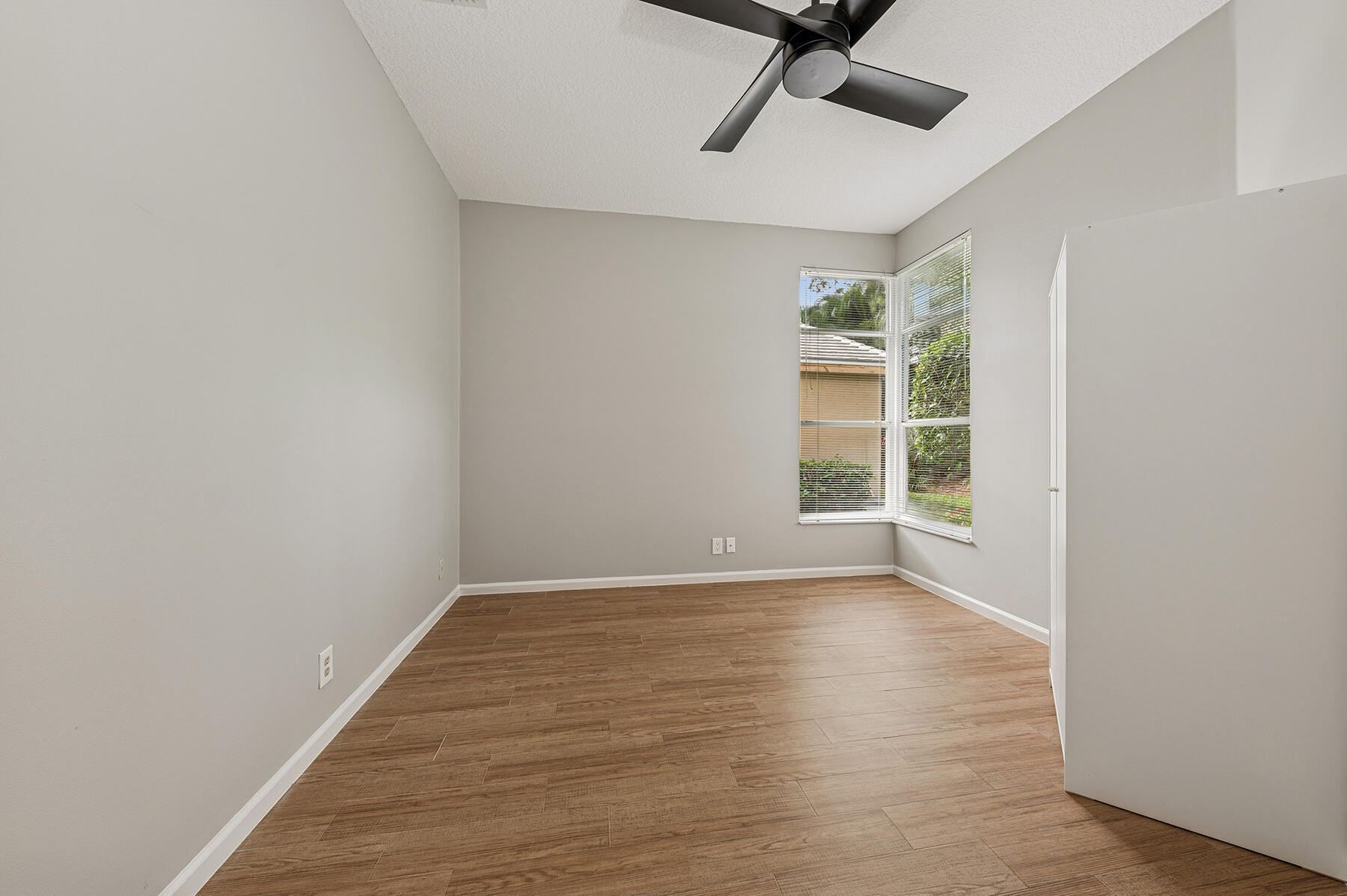 175 Harbor Lake Circle Greenacres, FL 33413 - Photo 18 of 33 a view of an empty room with a window and wooden floor