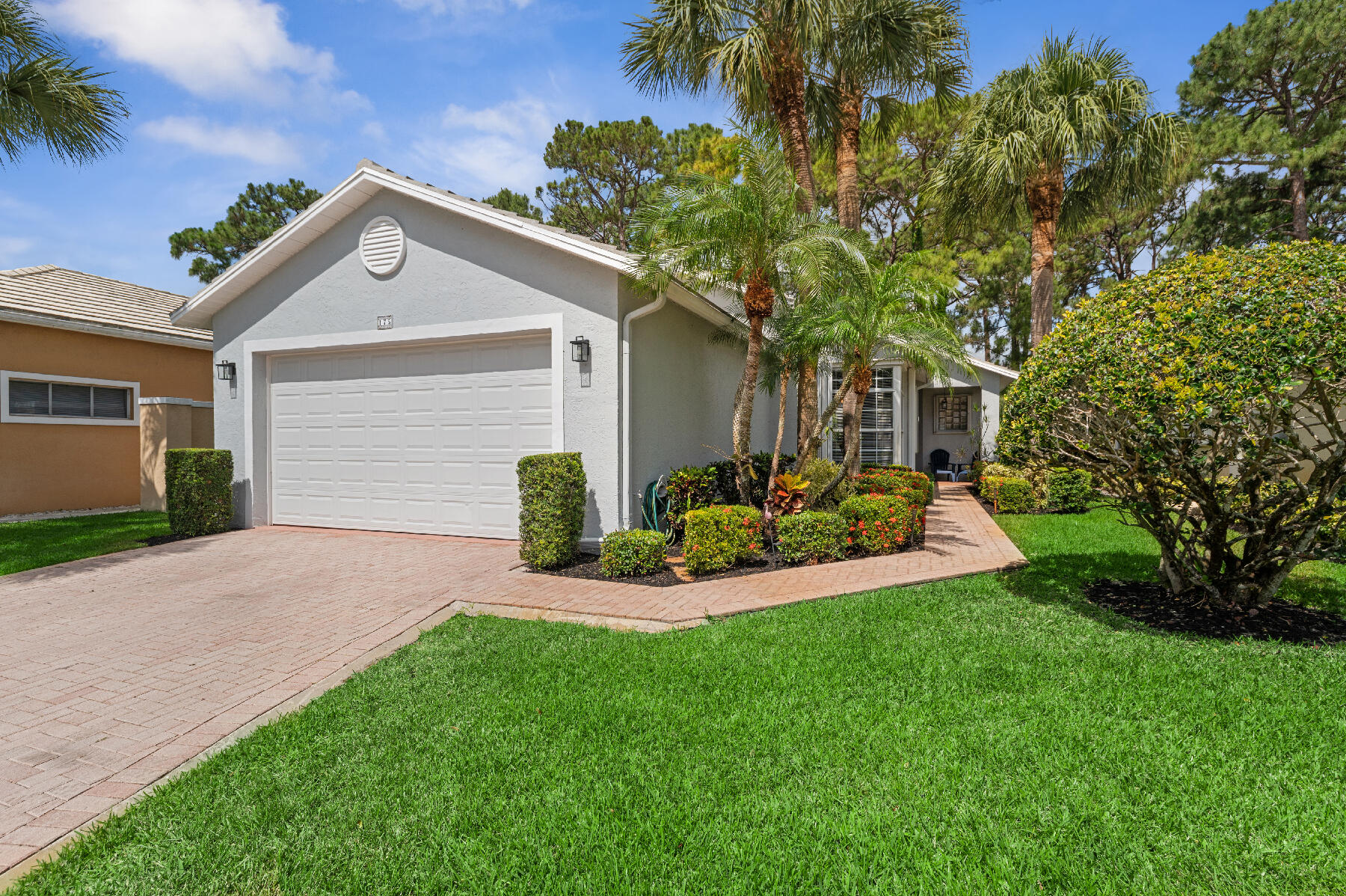 a front view of a house with a yard and potted plants