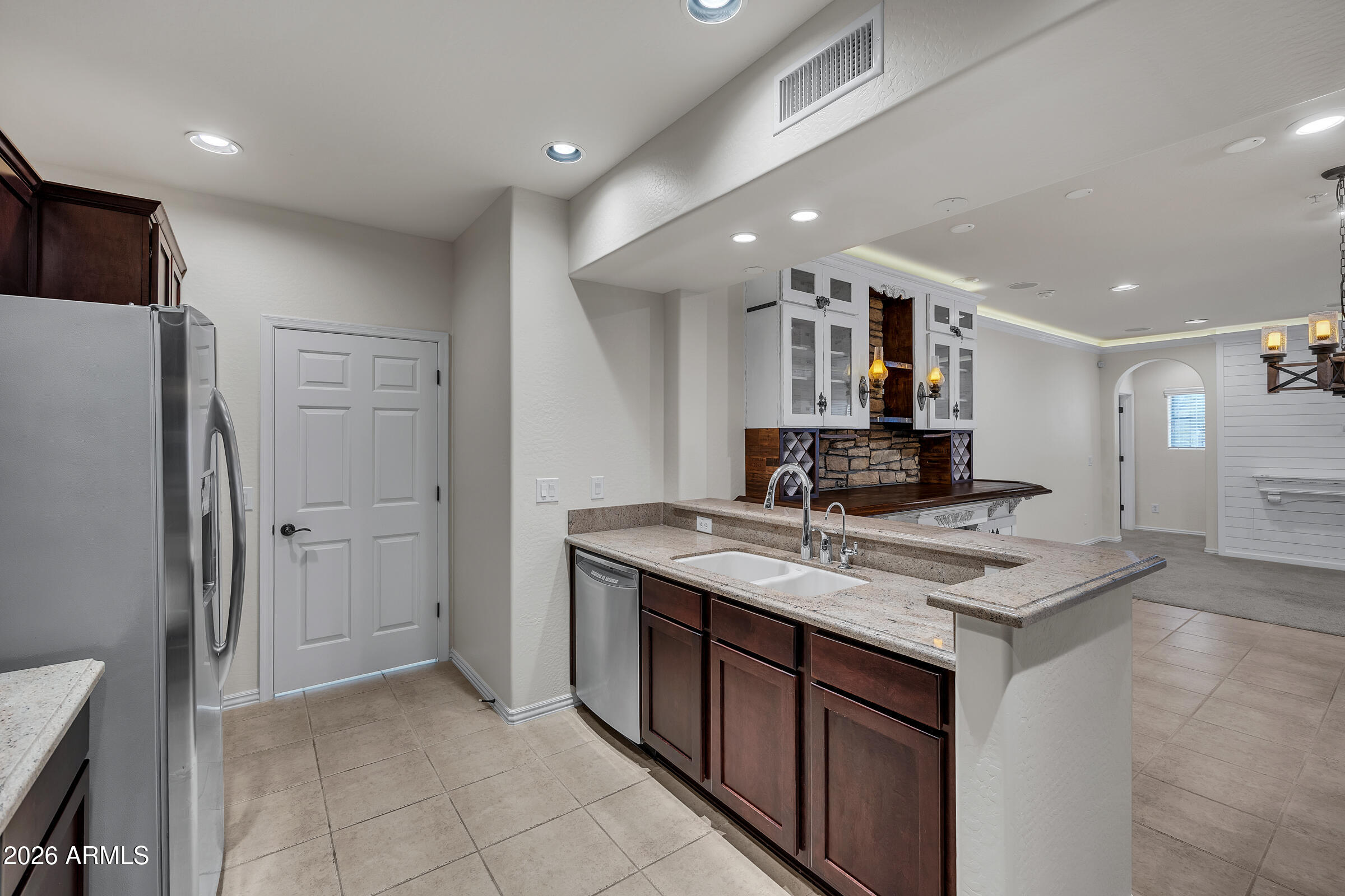 3935 East Rough Rider Road, Unit 1250 Phoenix, AZ 85050 - Photo 11 of 29 a kitchen with stainless steel appliances granite countertop a sink stove and refrigerator