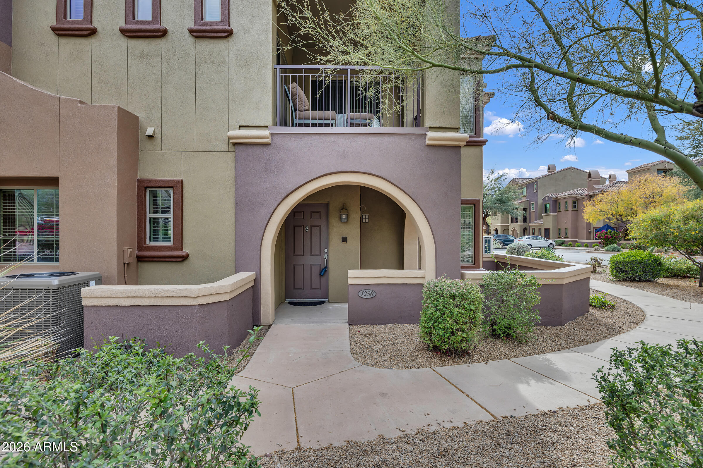 3935 East Rough Rider Road, Unit 1250 Phoenix, AZ 85050 - Photo 2 of 29 a front view of a house with a garden