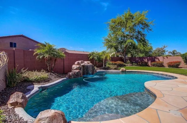 a backyard of a house with lots of green space and fountain