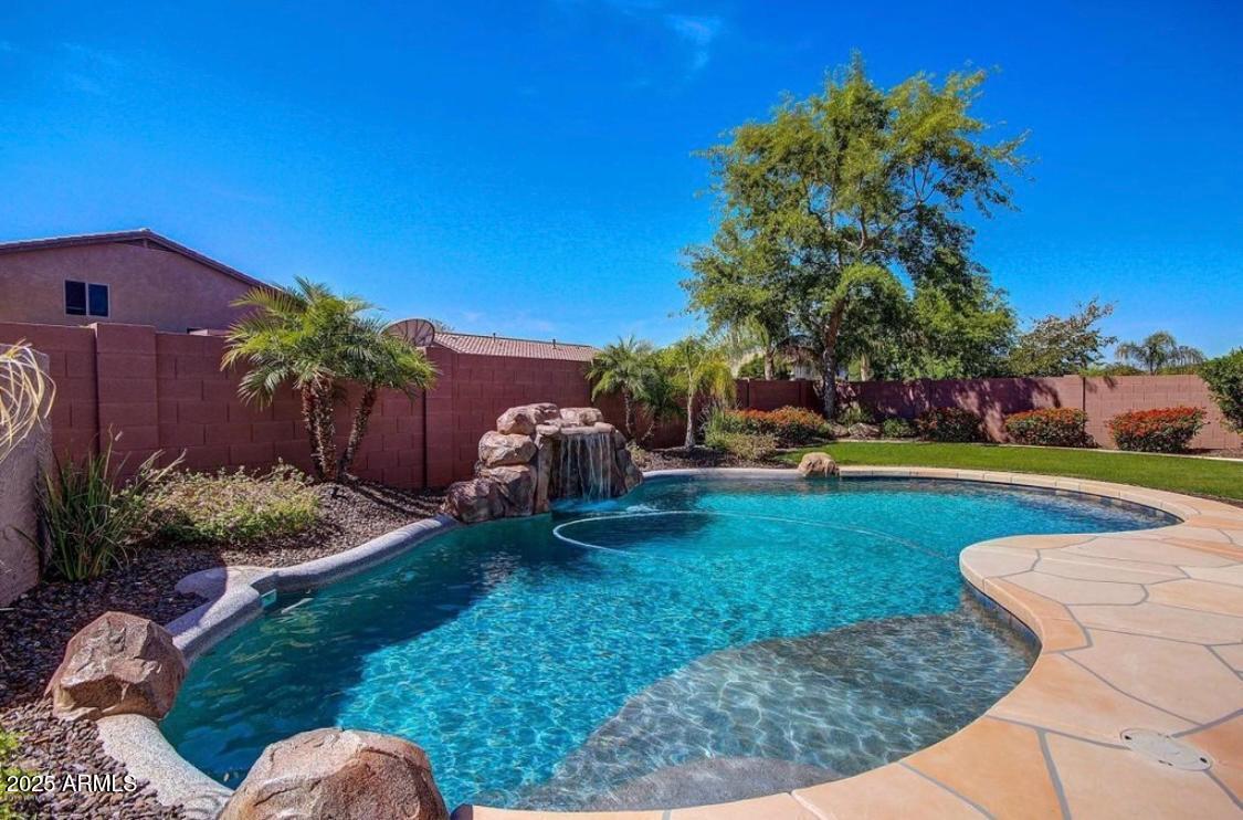 a backyard of a house with lots of green space and fountain