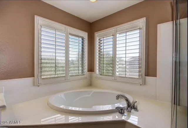 a white bath tub sitting in a bathroom next to a window