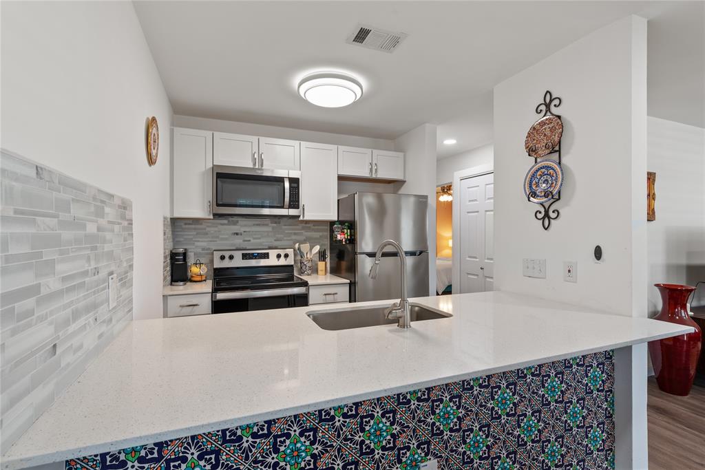 6409 Burns Street, Unit 107 Austin, TX 78752 - Photo 8 of 20 a kitchen with sink cabinets and microwave