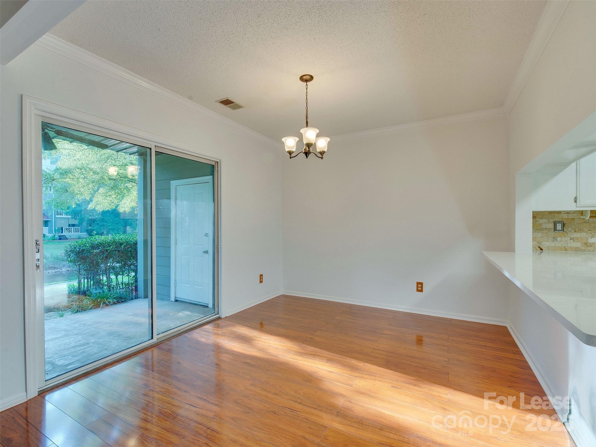 19827 Henderson Road, Unit B Cornelius, NC 28031 - Photo 11 of 48 en empty room with window and wooden floor