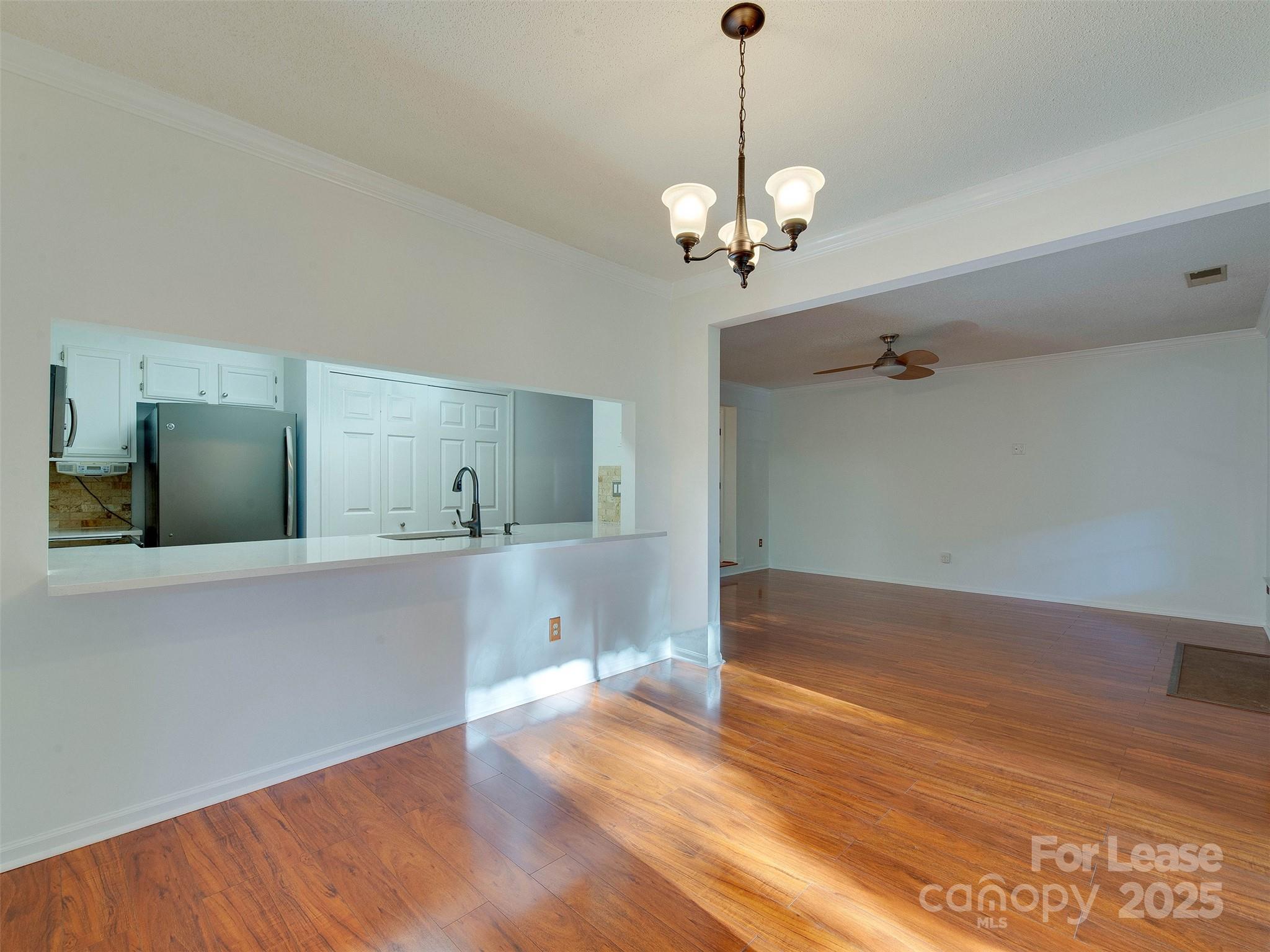 19827 Henderson Road, Unit B Cornelius, NC 28031 - Photo 13 of 48 a view of a room with a chandelier and wooden floor