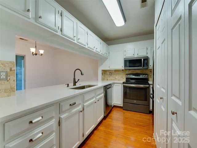 a kitchen with stainless steel appliances a sink stove and cabinets
