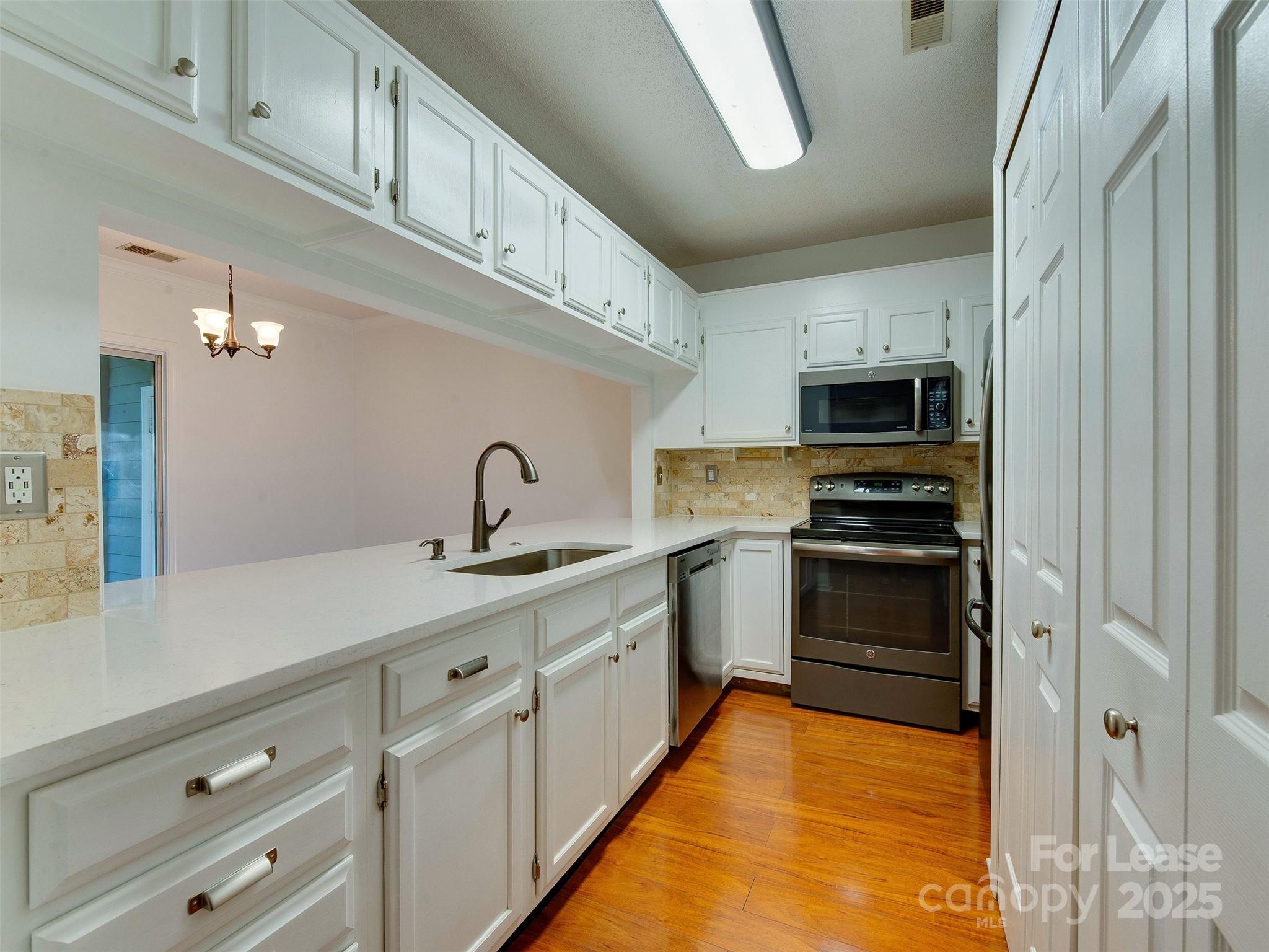 19827 Henderson Road, Unit B Cornelius, NC 28031 - Photo 14 of 48 a kitchen with stainless steel appliances a sink stove and cabinets