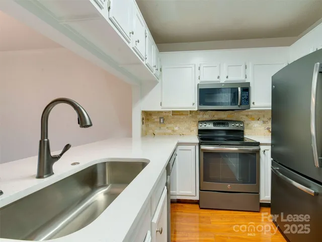 a kitchen with a sink cabinets and stainless steel appliances