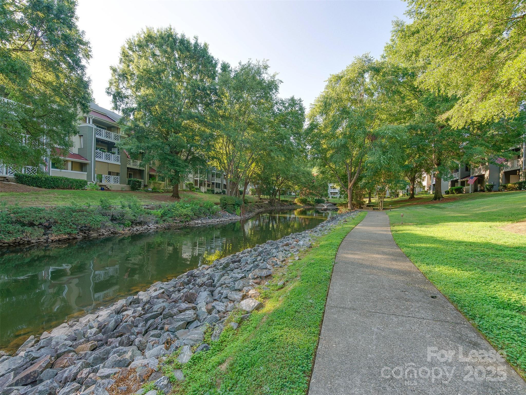 19827 Henderson Road, Unit B Cornelius, NC 28031 - Photo 32 of 48 a view of a lake with a big yard and large trees
