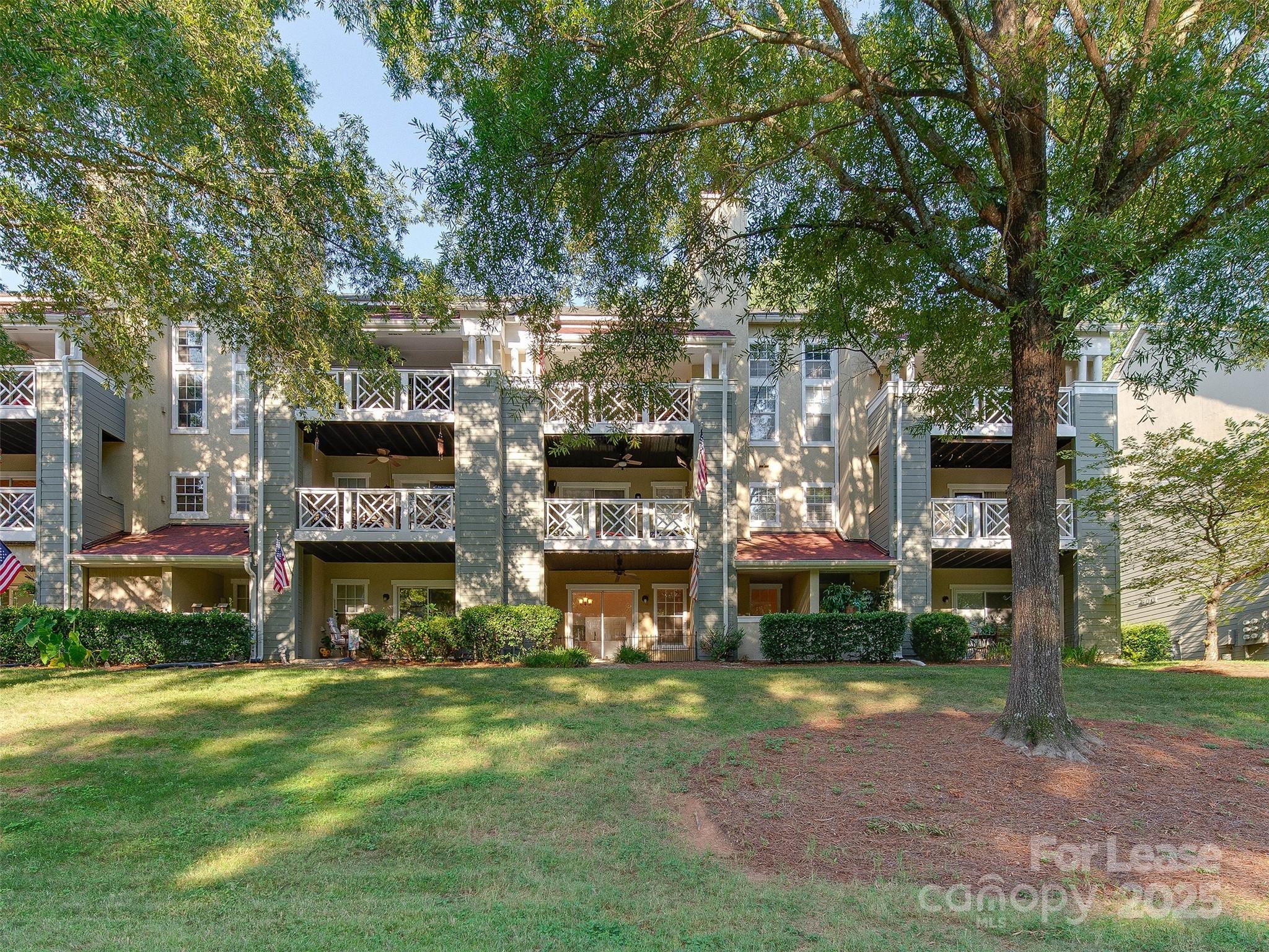 19827 Henderson Road, Unit B Cornelius, NC 28031 - Photo 33 of 48 a large building with a big yard and a large trees