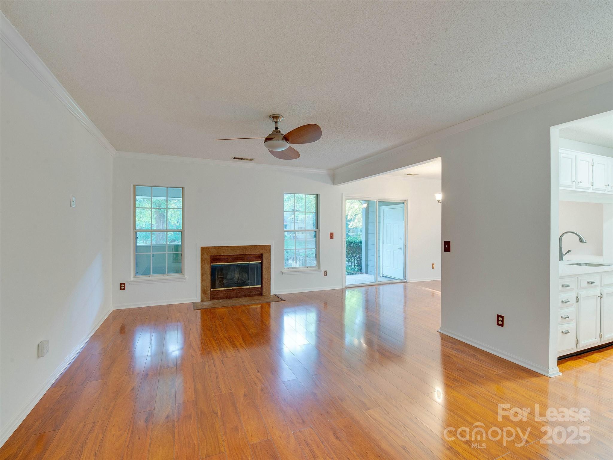 19827 Henderson Road, Unit B Cornelius, NC 28031 - Photo 5 of 48 a view of a livingroom with wooden floor a fireplace and window