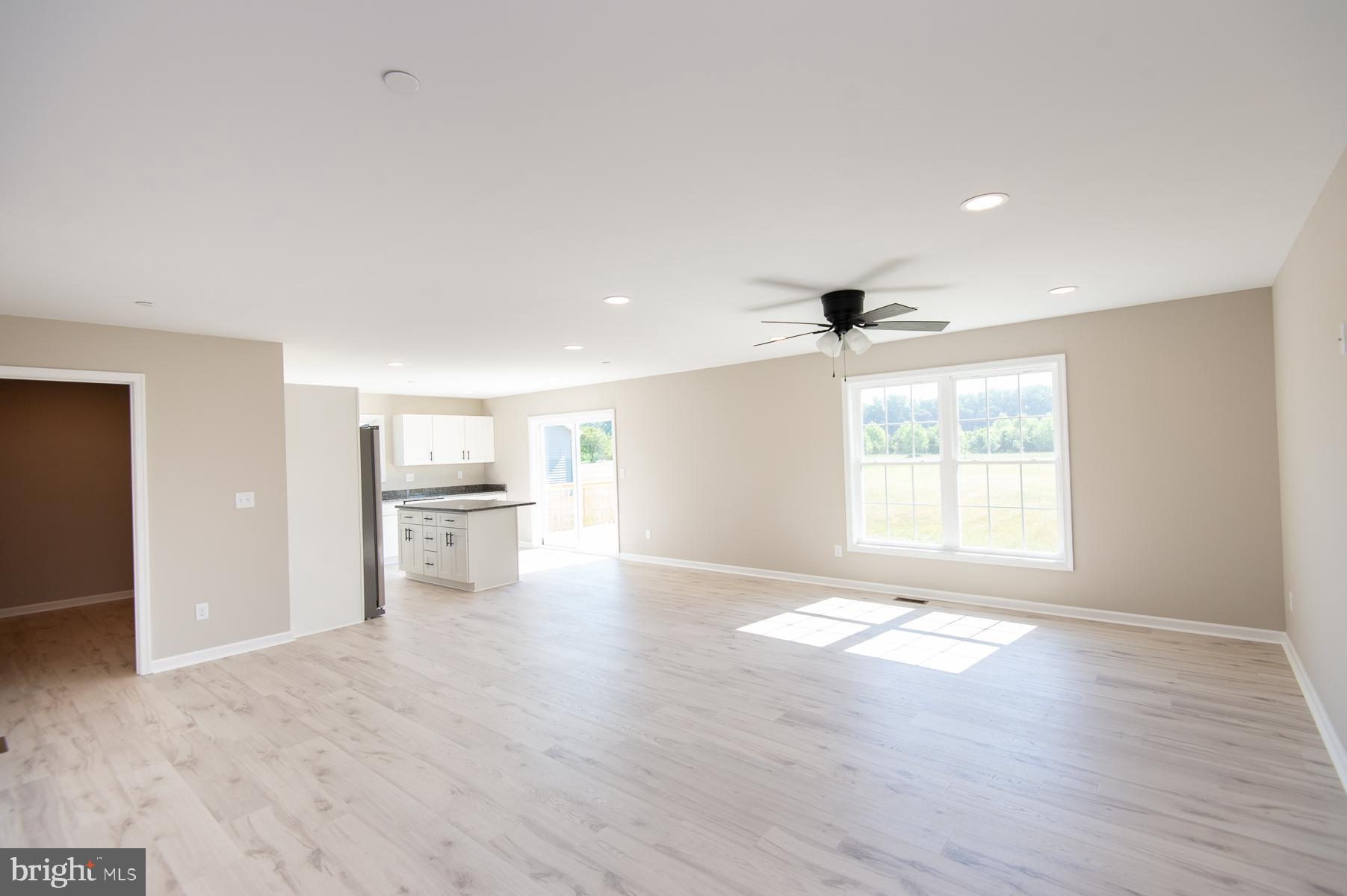 Wrights Rest Road Hurlock, MD 21643 - Photo 15 of 22 an empty room with windows and kitchen view
