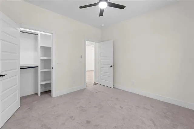 an empty room with closet and windows