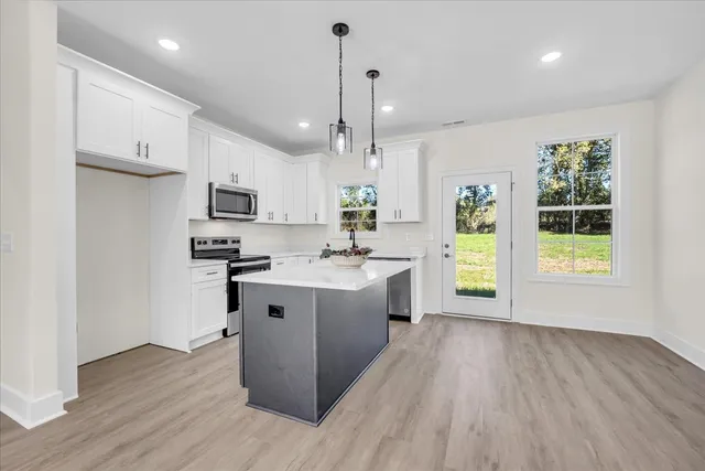 a kitchen with wooden floors and white cabinets