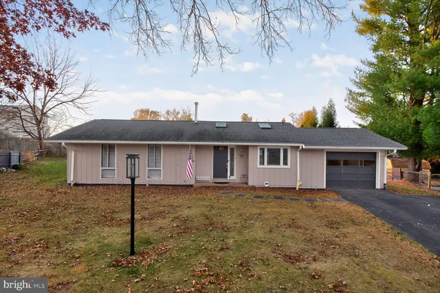 a view of a yard in front of a house with large tree