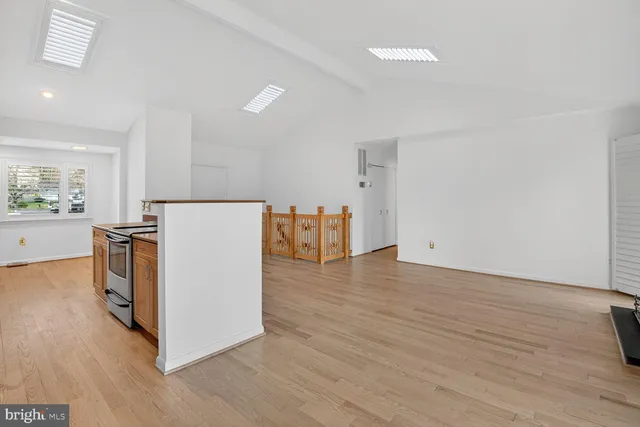 a view of a kitchen with a refrigerator and wooden floor
