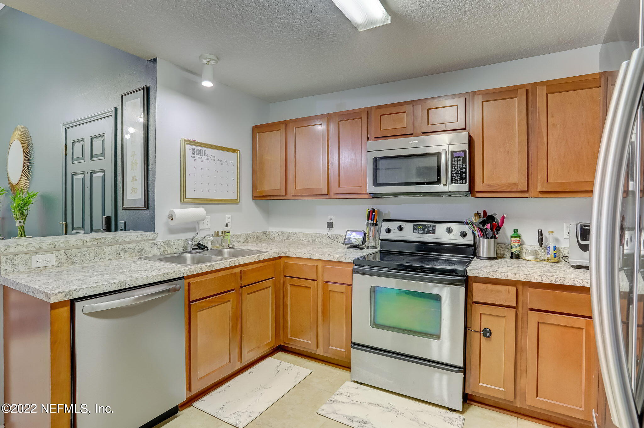 3690 Kirkpatrick Circle, Unit 710 Jacksonville, FL 32210 - Photo 15 of 34 a kitchen with stainless steel appliances granite countertop a stove top oven a sink dishwasher and a microwave oven with cabinets
