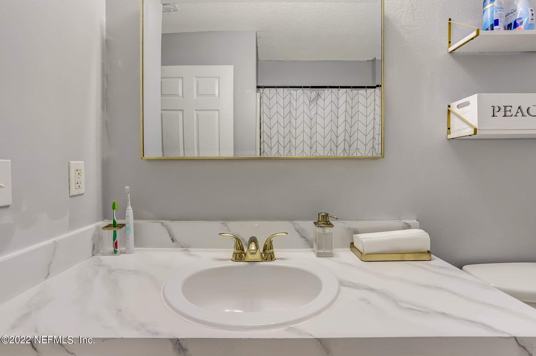 3690 Kirkpatrick Circle, Unit 710 Jacksonville, FL 32210 - Photo 30 of 34 a bathroom with a sink and a mirror