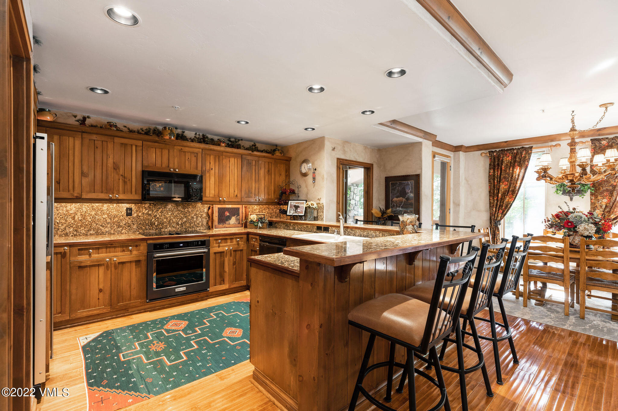 51 Offerson Road, Unit 114 Beaver Creek, CO 81620 - Photo 6 of 30 a kitchen with stainless steel appliances granite countertop a stove top oven a sink a dining table and chairs