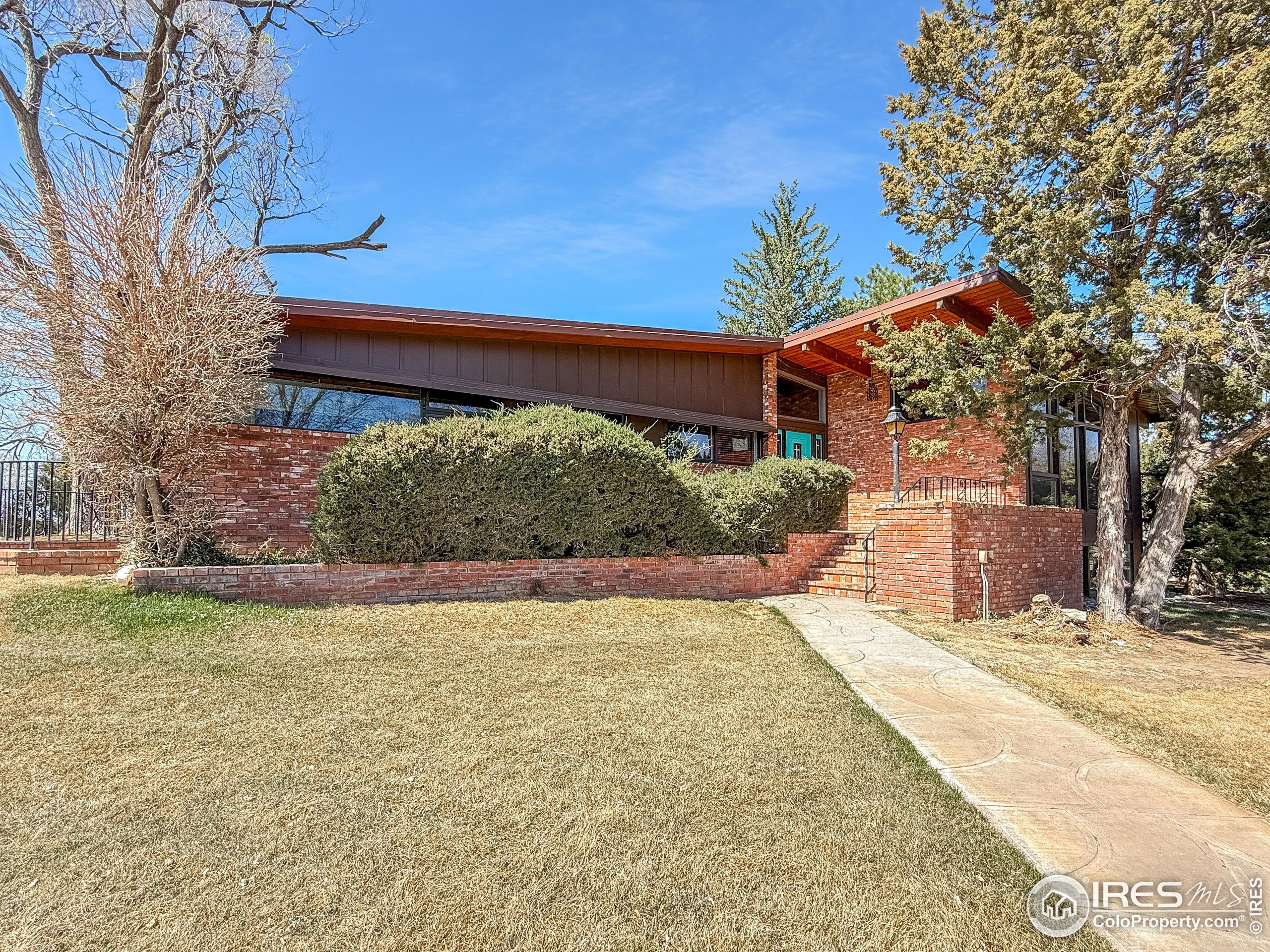 13302 County Road Sterling, CO 80751 - Photo 4 of 40 a front view of a house with a yard and garage