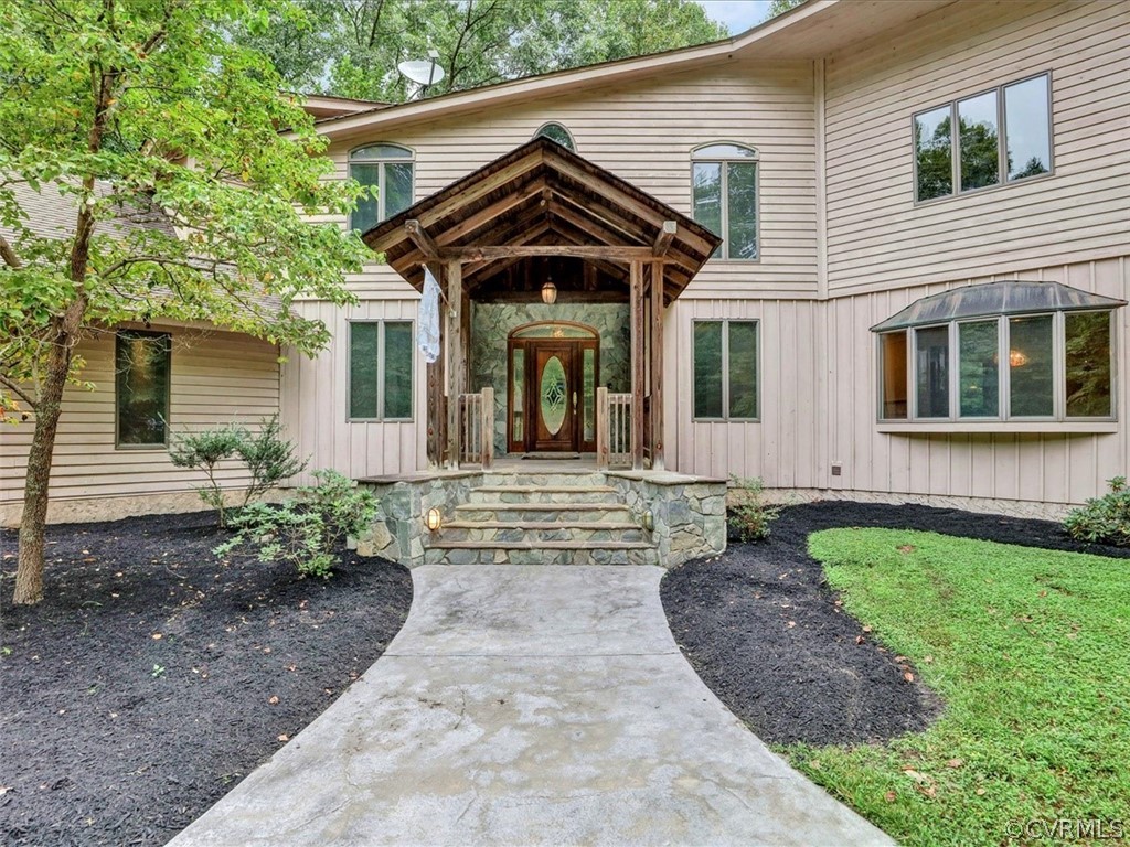 7461 Pine Ridge Road Mechanicsville, VA 23116 - Photo 2 of 42 a front view of a house with garden