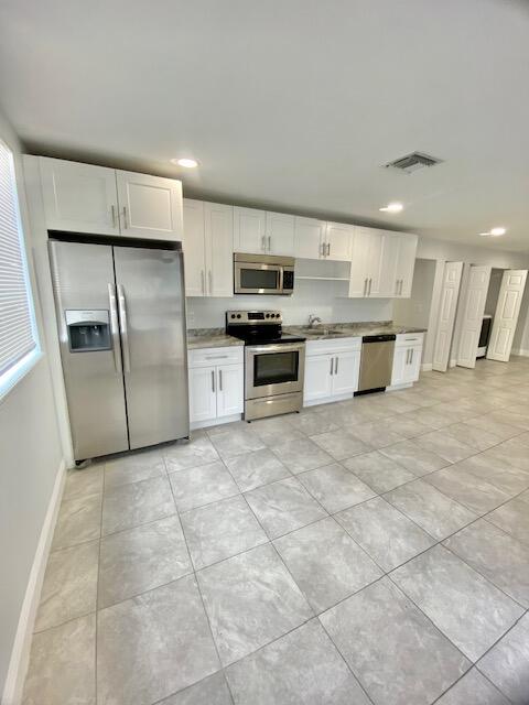 a large kitchen with cabinets and stainless steel appliances