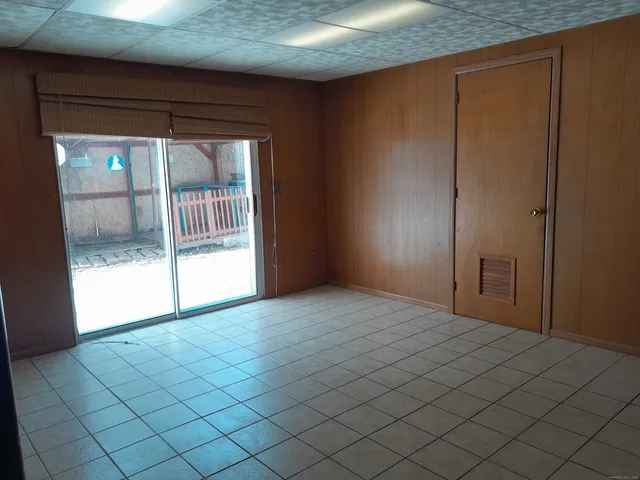 a view of empty room with wooden floor and next to window