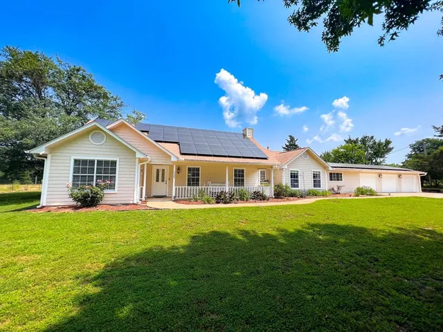 a front view of a house with a yard and trees