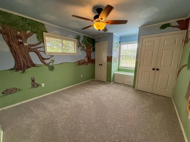 a view of a livingroom with a fan and a large window