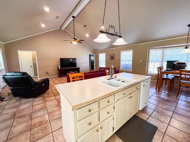 a large kitchen with kitchen island granite countertop a stove and a sink