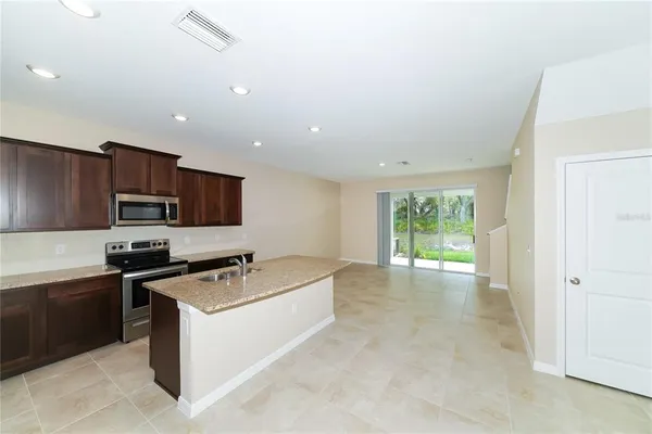 a kitchen with stainless steel appliances granite countertop a stove a sink and a refrigerator
