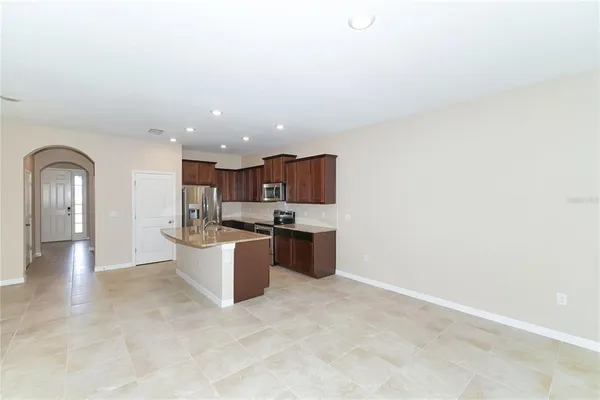 a view of living room with kitchen island stainless steel appliances wooden floor and view living room