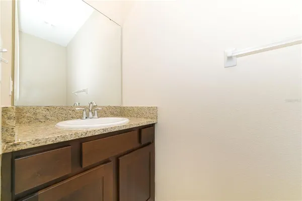 a bathroom with a granite countertop sink and a mirror