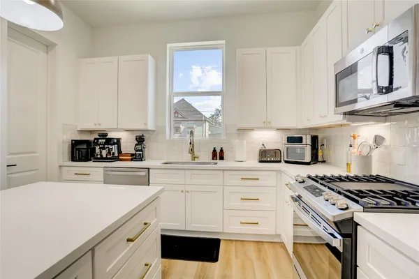 a kitchen with cabinets appliances a sink and a window
