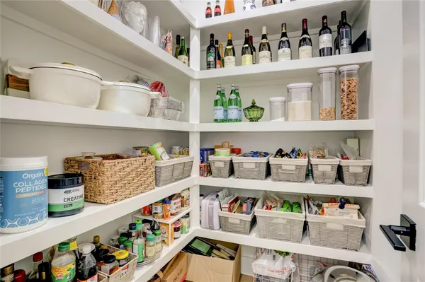 a cabinet with lots of clutter and white cabinets