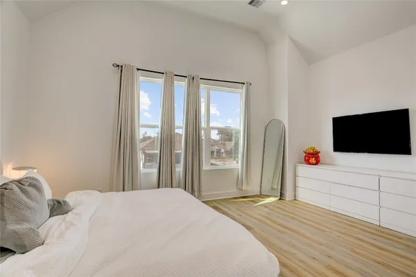 a bedroom with a bed and a flat screen tv