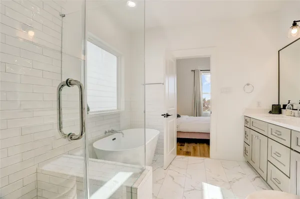 a bathroom with a tub sink and mirror