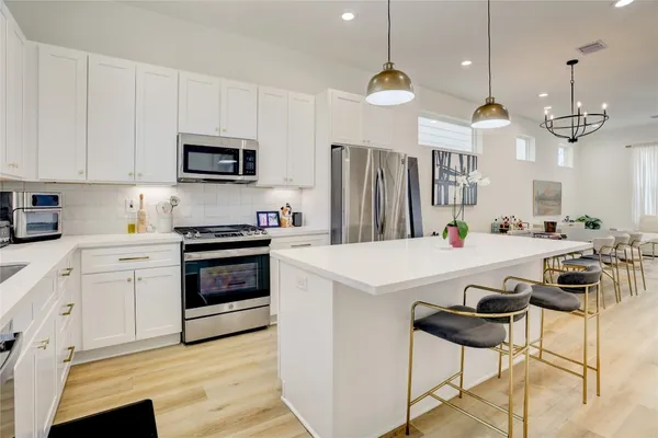 a kitchen with kitchen island white cabinets and stainless steel appliances