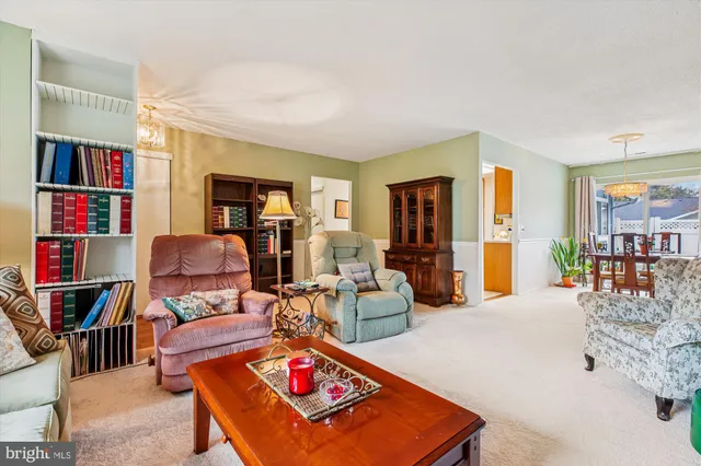 a living room with furniture a flat screen tv and a bookshelf