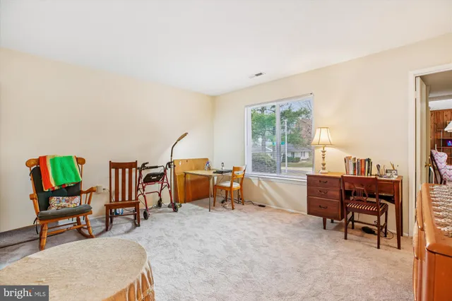 a living room with furniture a desk and large windows
