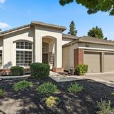 a view of a house with a yard and potted plants