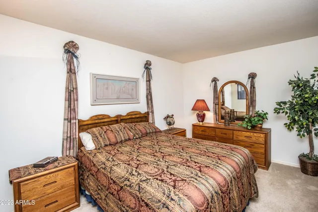 a bedroom with a bed and a dresser with mirror